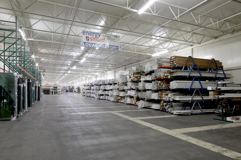 A warehouse with shelves and racks where a window replacement company stores their replacement windows and doors.