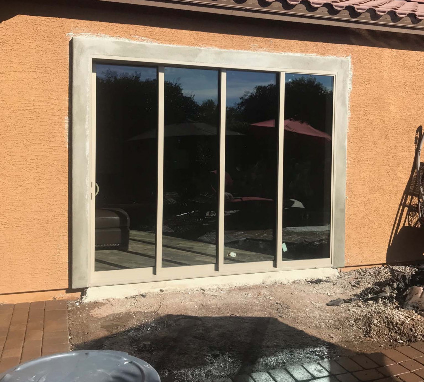 A sliding glass door is being installed in a house by a replacement doors company.