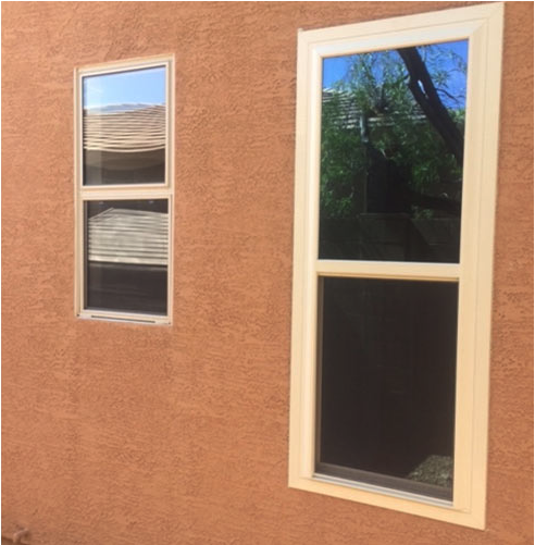 A window replacement company installed two replacement windows in a house with a tan wall.