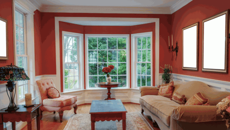 A living room with red walls that could benefit from the services of a window replacement company.